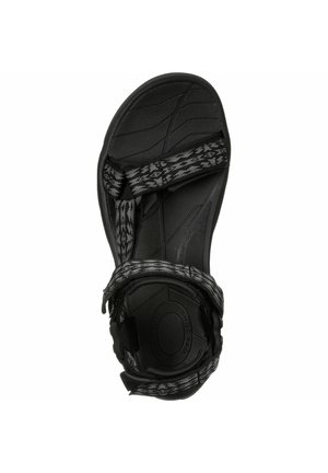 Black sandal with textured rubber sole, featuring adjustable woven straps in a black and gray geometric pattern. Lightweight design.