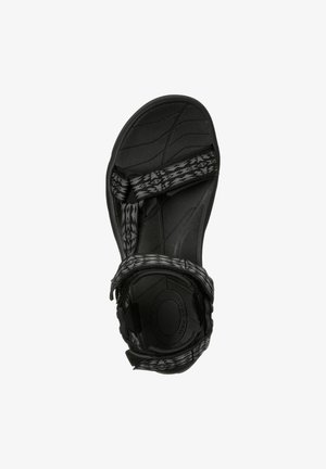 Black sandal with textured rubber sole, featuring adjustable woven straps in a black and gray geometric pattern. Lightweight design.