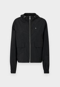 Czarna kurtka z zapięciem na zamek z przodu, dwoma dużymi kieszeniami z przodu, regulowanym kapturem i elastycznymi mankietami. Wykonana z lekkiego, gładkiego materiału.