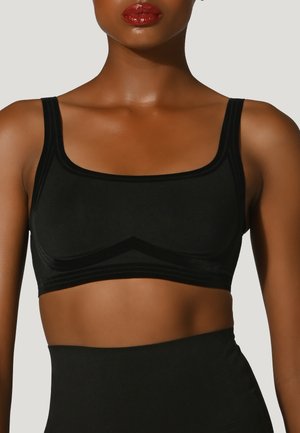 Sort stof bralette med firkantet udskæring, brede stropper og subtile teksturdetaljer langs sømmene. Længden slutter lige over taljen.