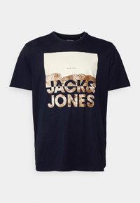 Navy blue bawełniana koszulka z białym i brązowym nadrukiem graficznym oraz napisem "JACK & JONES". Standardowy okrągły dekolt, krótkie rękawy i luźny krój.