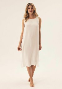 Biała sukienka bez rękawów, wykonana z lekkiego materiału, z okrągłym dekoltem i swobodnym krojem, charakteryzująca się miękką, teksturowaną powierzchnią.