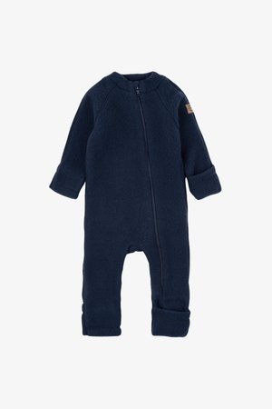 Tumši zilā velūra kombinezons ar priekšējo rāvējslēdzēju, garām piedurknēm un sarullētām aprocēm. Satur nelielu auduma birku uz pleca. Mīksta tekstūra.