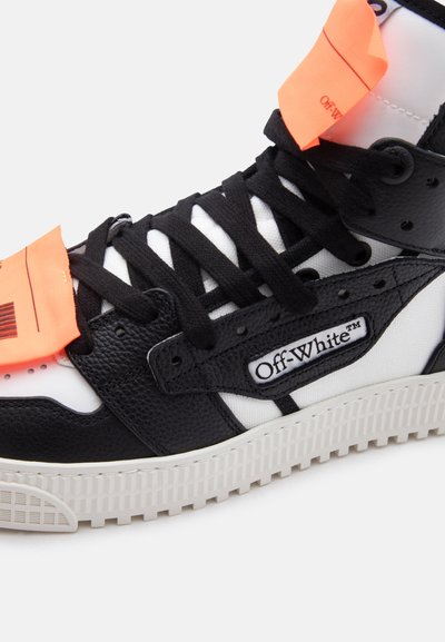 Ασπρόμαυρο ψηλό αθλητικό παπούτσι Off-White με μαύρα κορδόνια, πορτοκαλί ετικέτες και υφασμένο λευκό καουτσούκ σόλα.