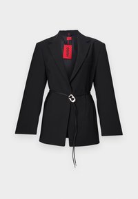 Black blazer with a fitted design, featuring a belted waist and silver circular hardware. Includes a single chest pocket and a red tag.