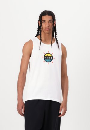 Biały bawełniany top na ramiączkach z okrągłym, wielokolorowym logo Nike na środku. Projekt zawiera promienie w pomarańczowych, żółtych i czerwonych akcentach.
