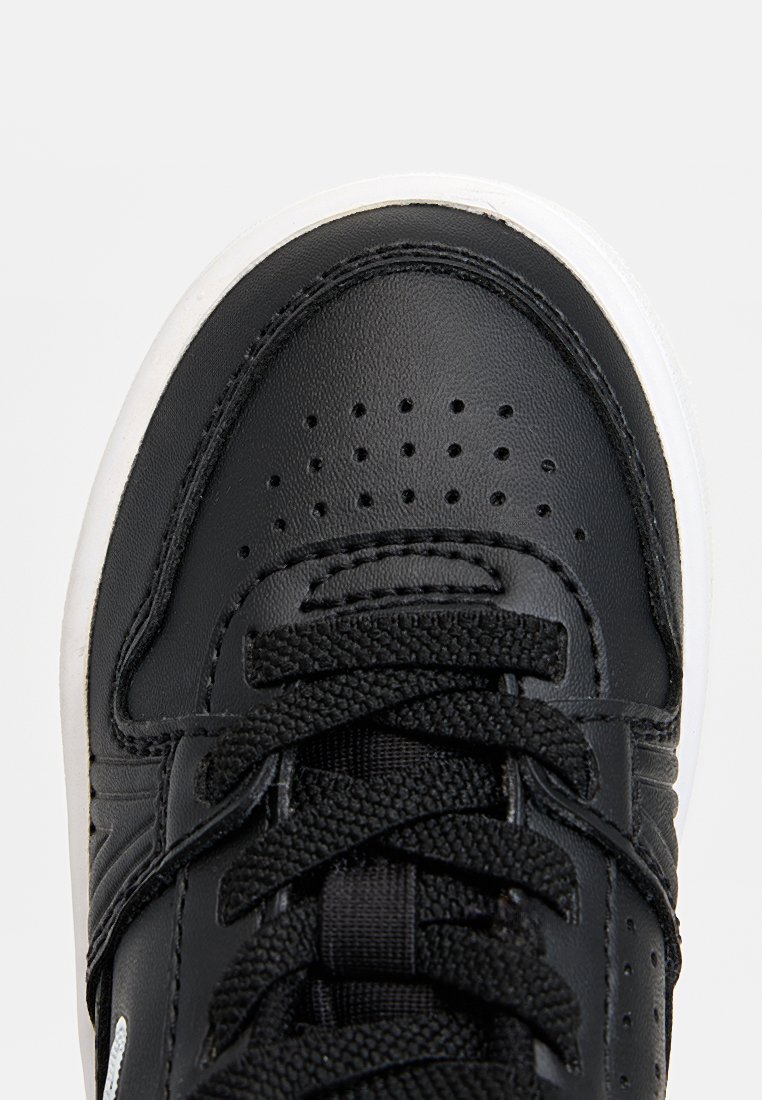 Zwarte sneaker met een glad leren bovenwerk, gestructureerde veters, geperforeerde neuskap en een witte rubberen zool. Minimalistisch ontwerp, geen zichtbare logo's.