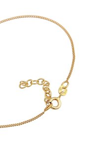 Collana a catena tono oro con un design liscio e arrotondato. Presenta una chiusura sicura e una lunghezza regolabile con anelli interconnessi.