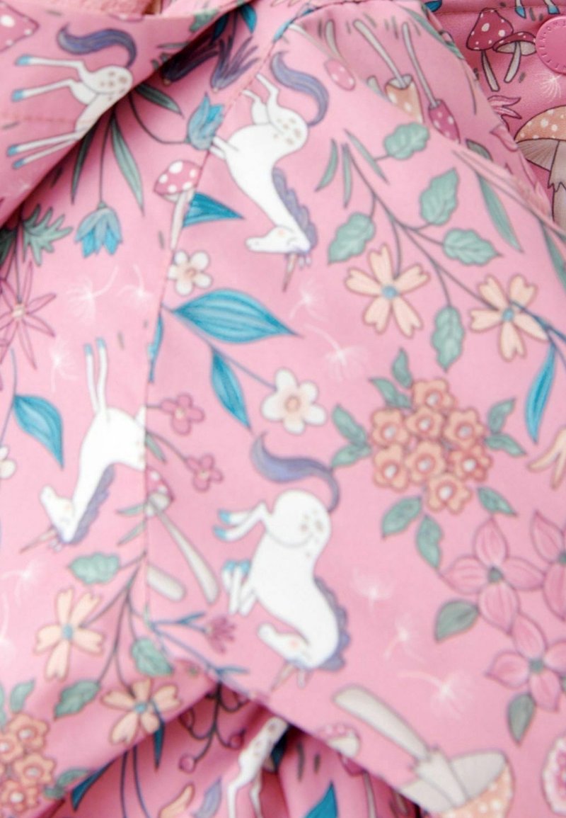 Tissu rose présentant un motif fantaisiste de licornes, de fleurs et de champignons, avec des feuilles vertes et des accents floraux colorés partout.
