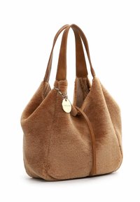 Sac à main en fourrure marron avec une texture douce, des poignées en cuir, des détails cousus et un accent en métal, affichant une forme arrondie et décontractée.