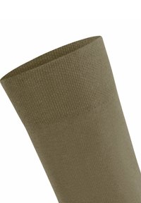 Skarpeta w oliwkowym zielonym kolorze z teksturowanym, prążkowanym wzorem, z szerokim mankietem i gładkim ciałem, wykonana z miękkiego materiału dzianinowego.