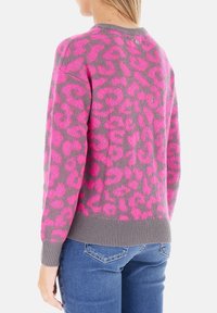 Maglione in maglia grigia con stampa leopardata rosa brillante. Presenta un collo rotondo e polsini e orlo a costine. Dettaglio con un bottone sul retro.