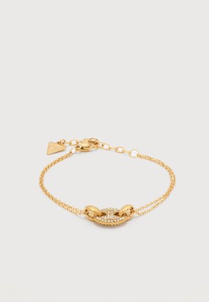 Gullfarget dobbelt kjede armbånd med oval sentralledd dekorert med små klare krystaller og en liten trekantet charm nær låsen.