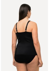 Haut de bain noir avec bretelles réglables, texture lisse et coupe ajustée. Associé à un bas de bain noir assorti.