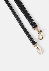 Svart läderrem med guldfärgade metallklipp, utrustad med vit sömnad, designad för hållbarhet och bekväm fäste.