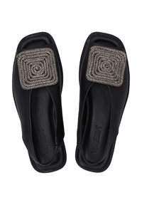 Černé kožené slip-on boty s čtvercovým ozdobným kamínkem na špičce, s hladkým povrchem a otevřeným designem vzadu.