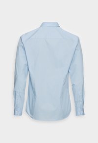 Camicia a maniche lunghe azzurro chiaro con colletto a boutonnière. Caratterizzata da una texture morbida, una vestibilità sagomata e bottoni decorativi sui polsini.
