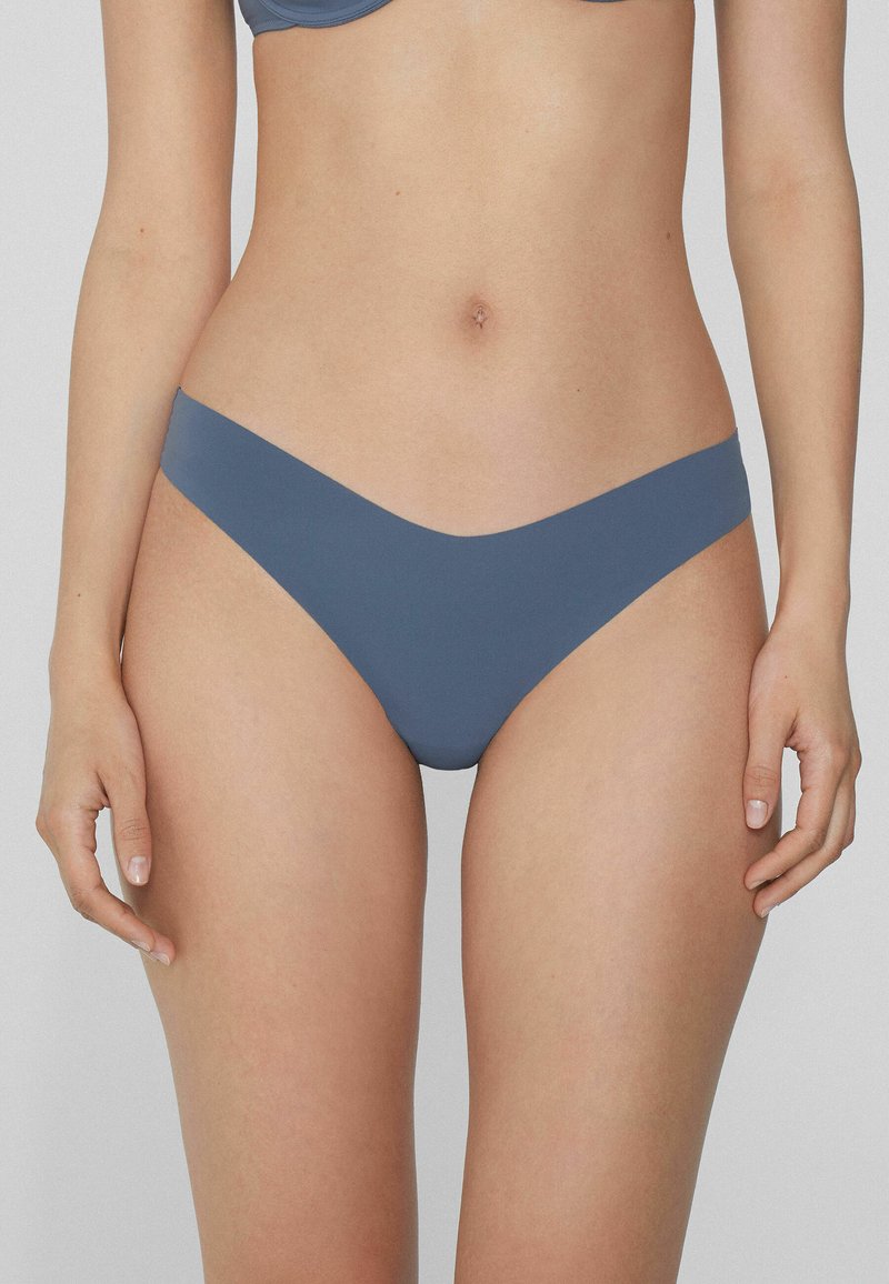 Blaue Bikini-Unterteile mit nahtlosem Design, niedrig geschnitten und aus glattem, dehnbarem Stoff. Minimale Details und keine Muster.