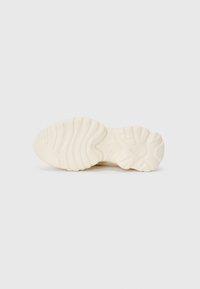 Cream outsole with textured surface and pronounced ribbed pattern. Features rounded edges and sculptural contours for traction.