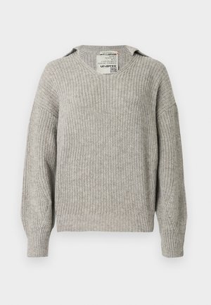 Jersey de punto gris claro con cuello en V, corte holgado, hombros caídos y puños acanalados. La tela presenta un patrón texturizado.