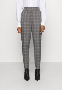 Gray plaid trousers with a tailored fit, high waist, and tapered legs, paired with black pointy-toed heels. Smooth fabric texture.