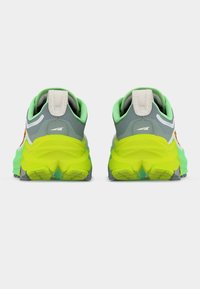 Ζευγάρι παπουτσιών ορεινού τρεξίματος με γκρι επάνω μέρος, φωτεινές κίτρινο-πράσινες σόλες και επένδυση μίντ πράσινου χρώματος, εμφανιζόμενα από πίσω σε λευκό φόντο.