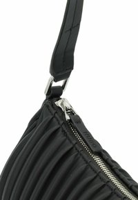 Zwarte, gewatteerde leren tas met een zilveren ritssluiting, een slanke verstelbare schouderband en een gladde textuur met geplooide ontwerpelementen.