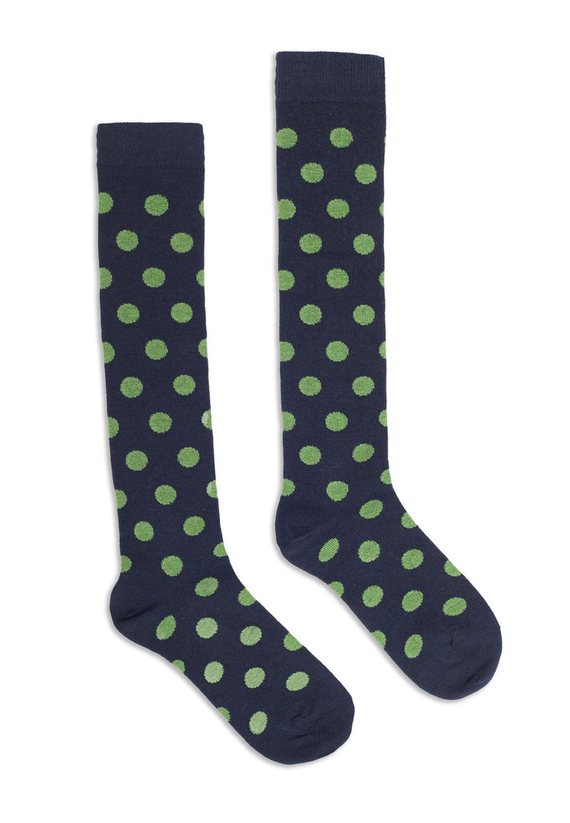 Une paire de chaussettes bleu marine montantes avec des pois verts régulièrement espacés, posées à plat sur un fond blanc.
