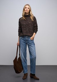 Suéter marrón de punto con textura y cuello alto, jeans azul claro de pierna recta y botines de ante marrón. Bolso tote marrón oscuro.