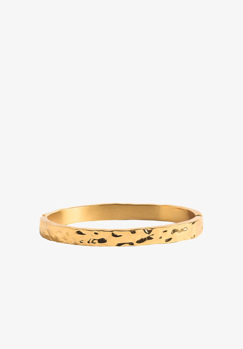 Złota, młotkowana bransoletka w kształcie okręgu z teksturowaną powierzchnią i gładkimi krawędziami.