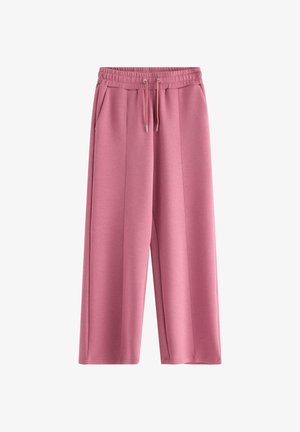 Pink sweatpants med vide ben, elastisk talje, snøretræk og sidelommer på hvid baggrund.