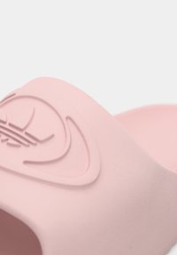 Ροζ σανδάλι με λουρί από μαλακό υλικό. Διαθέτει ανάγλυφη λεπτομέρεια με το λογότυπο στο λουρί και ανατομική σόλα για άνεση.