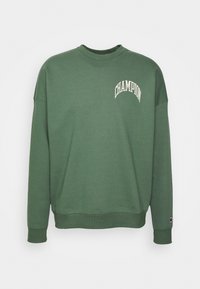 Zelená mikina vyrobená z bavlny, s kulatým výstřihem, dlouhými rukávy, žebrovanými manžetami a malým bílým logem "CHAMPION" na hrudi.