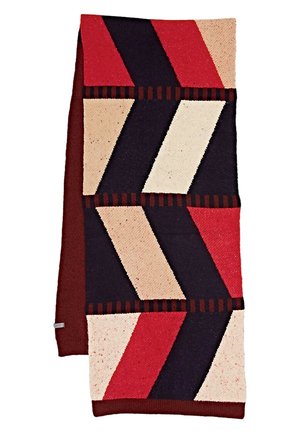 Écharpe en tricot avec un motif géométrique de blocs diagonaux rouges, beiges, noirs et marron foncé sur fond blanc.