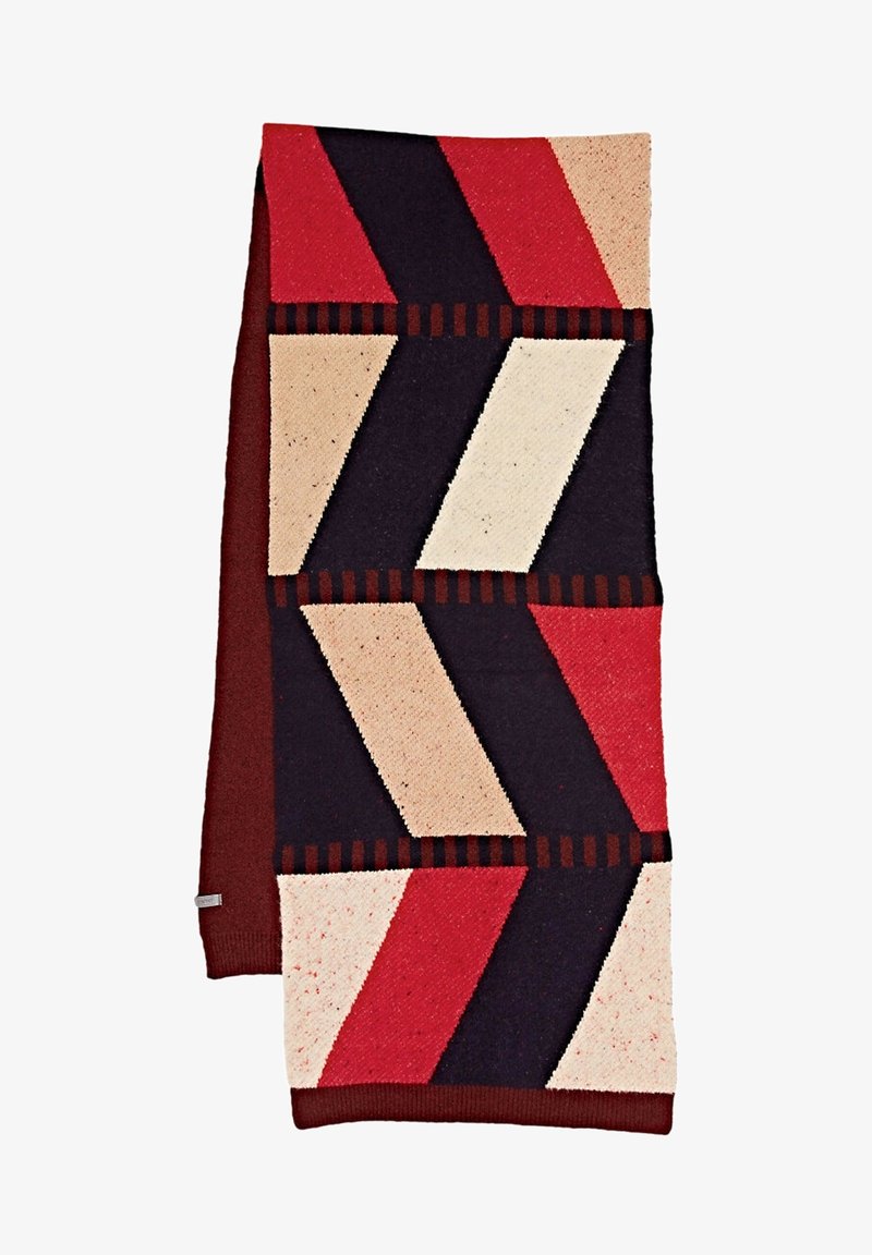 Écharpe en tricot avec un motif géométrique de blocs diagonaux rouges, beiges, noirs et marron foncé sur fond blanc.