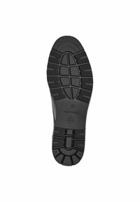 Semelle de chaussure en caoutchouc noir avec un relief texturé, des rainures en motifs et des zones de grip circulaires. Présente le nom de la marque embossé sur le côté.