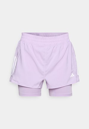 Lavendel sportshorts med elastisk talje, kontrasterende inderlag og hvide lodrette striber på siderne.