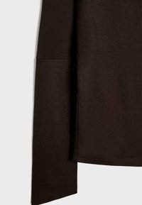 Camicia a maniche lunghe marrone con una texture morbida e liscia, orlo arrotondato e cuciture a contrasto lungo i bordi.
