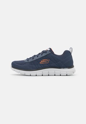 Zapatilla atlética de malla en color navy con suela blanca ligera, con acentos grises y un logo naranja, diseñada para la comodidad y la transpirabilidad.