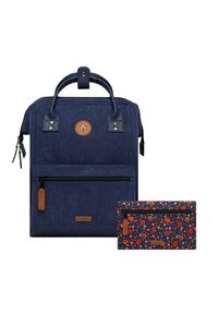 Sac à dos en velours côtelé bleu marine avec une poche zippée à l'avant, des accents en cuir et une pochette à motif floral. Il dispose de poignées solides et de zippers.