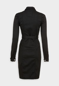 Svart denimklänning med en strukturerad krage, långa ärmar och midja med bälte. Har knäppta manschetter och sömdetaljer längs ryggen.