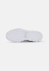 Shoe sole in white rubber with textured diamond pattern and slight curvature. Features PUMA logo in the center and vertical grooves along edges.