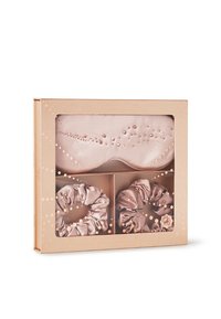 Il set include una maschera per gli occhi in satin rosa pallido adornata con cristalli e due scrunchies in satin abbinati, il tutto in una trasparente scatola regalo.