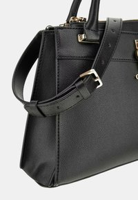 Borsa a mano in pelle nera con superficie testurizzata, dotata di tracolla removibile, dettagli in metallo dorato e forma strutturata.