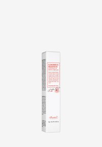 Envase rectangular blanco con texto rojo y negro, que presenta un personaje de dibujos animados. La etiqueta indica "Crema para manchas Centella Goodbye Redness".
