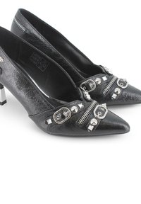 Zapatos de tacón alto negros hechos de cuero artificial texturizado. Presentan tachuelas plateadas, cremalleras y un diseño de punta afilada.