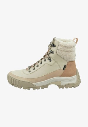 Botas de senderismo de color beige claro con un suave ribete de piel de pelo, acentos de ante, ojales de metal y una suela de goma resistente para mayor tracción.