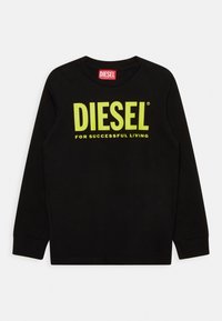 Černé dlouhé rukávy tričko vyrobené z bavlny. Na přední straně se nachází jasně žluté logo "DIESEL" a slogan "PRO ÚSPĚŠNÝ ŽIVOT" v tučném písmu.