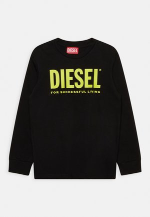 Černé dlouhé rukávy tričko vyrobené z bavlny. Na přední straně se nachází jasně žluté logo "DIESEL" a slogan "PRO ÚSPĚŠNÝ ŽIVOT" v tučném písmu.