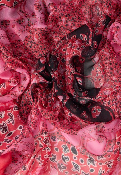 Κόκκινο και ροζ διαφανές ύφασμα με μαύρα και λευκά σχέδια λεοπάρδαλης και λουλουδιών, χαλαρά συγκεντρωμένο και στρωμένο.